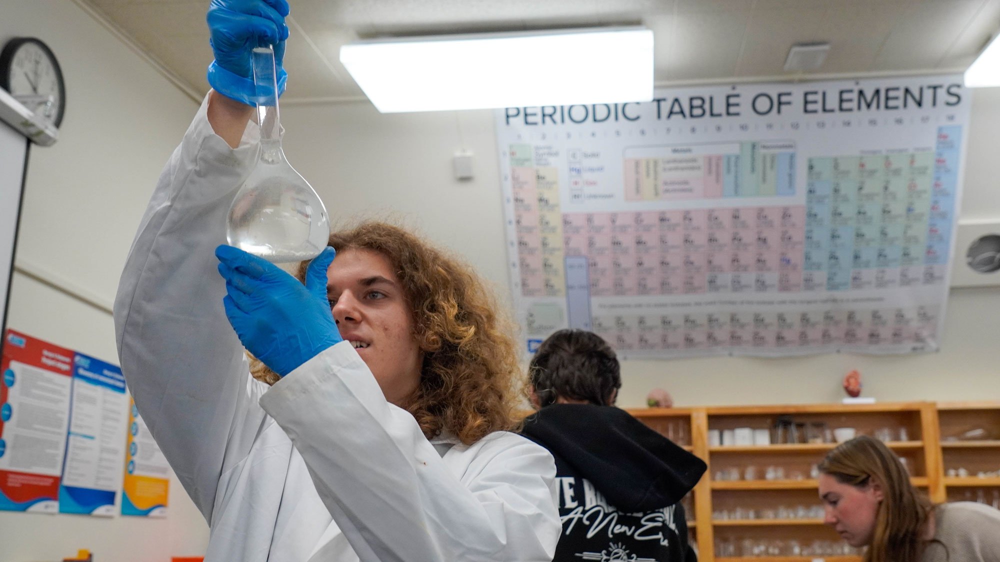 Student looking at liquid in a beaker in the light