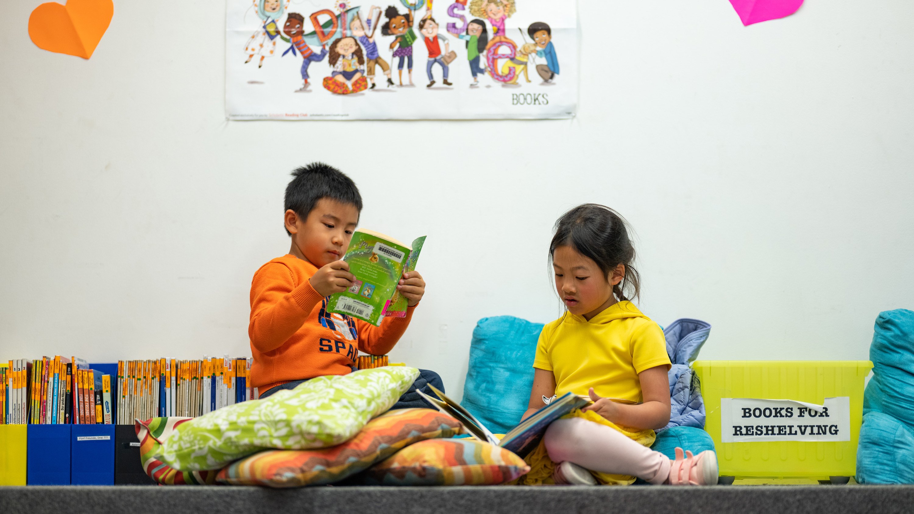 Young Chinese Program students reading together in the library.
