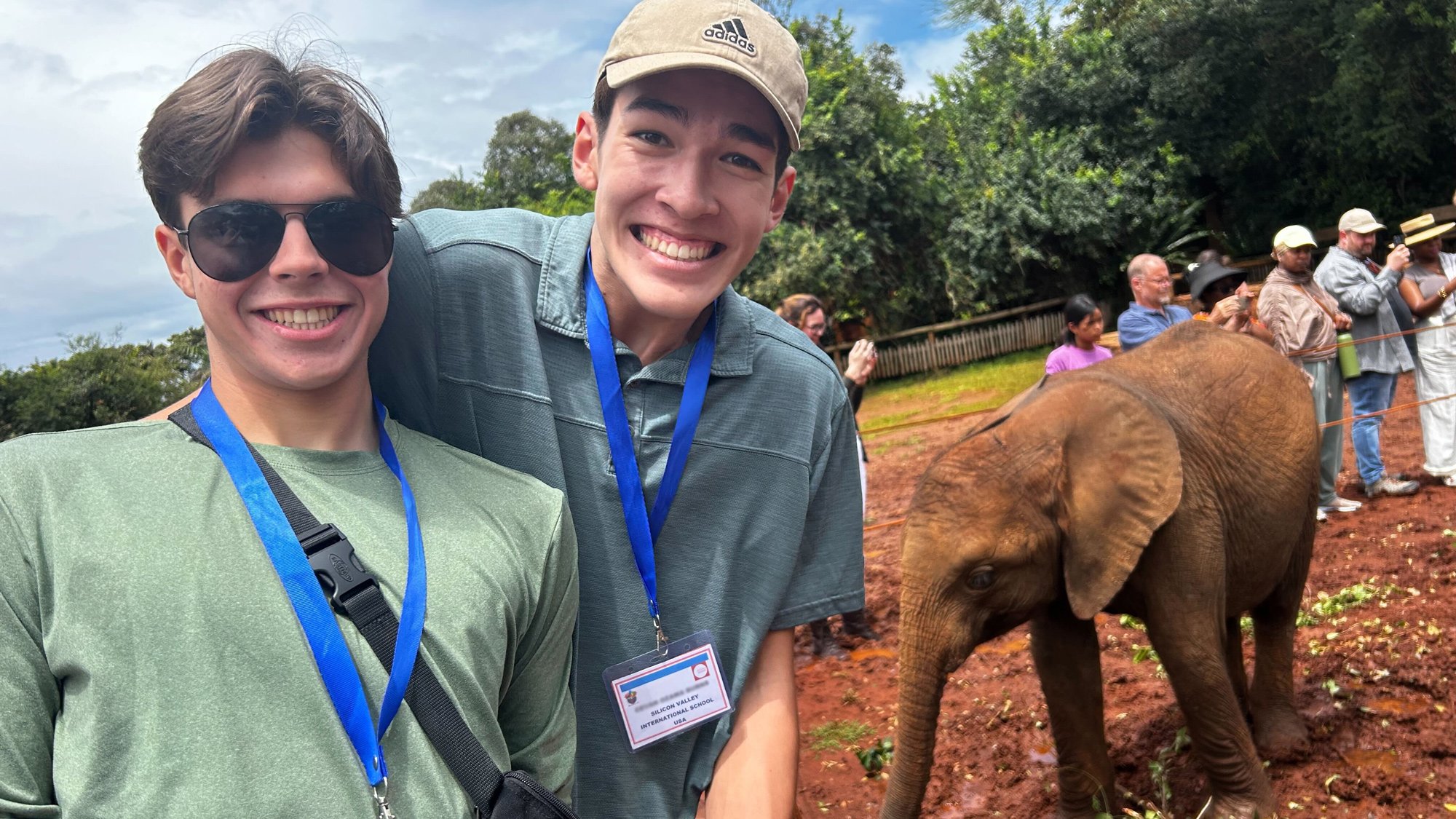 Two INTL juniors posing in front of a baby elephant at the elephant orphanage center.