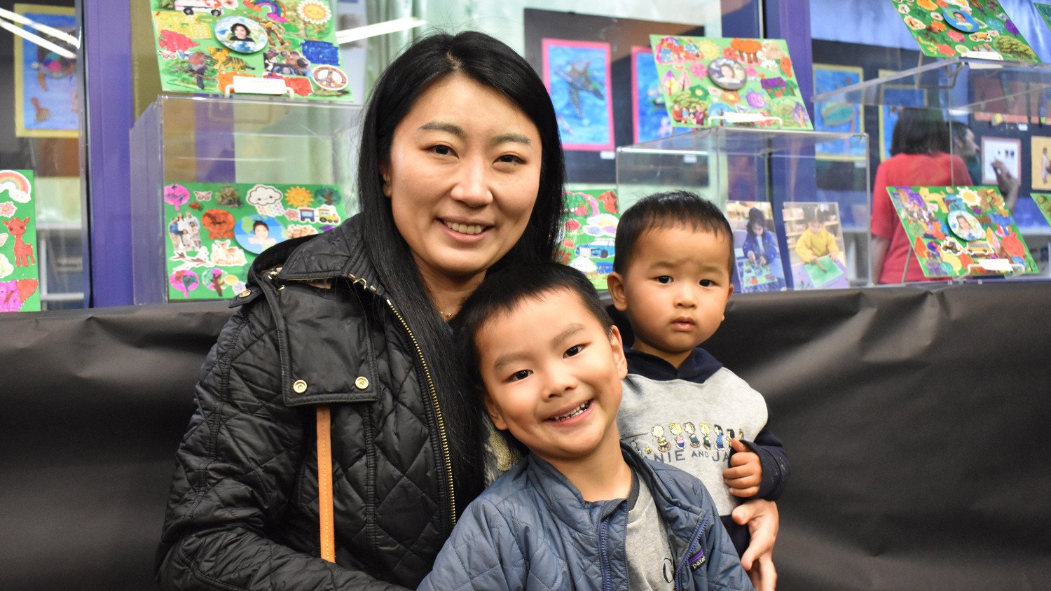 A mother and her two sons posing in front of one of the exhibits