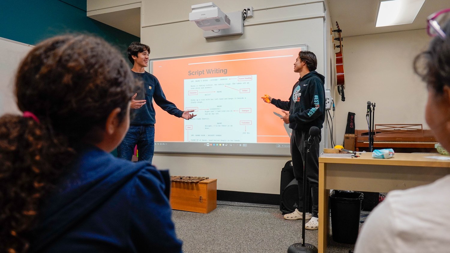 Two students present on script writing during film club