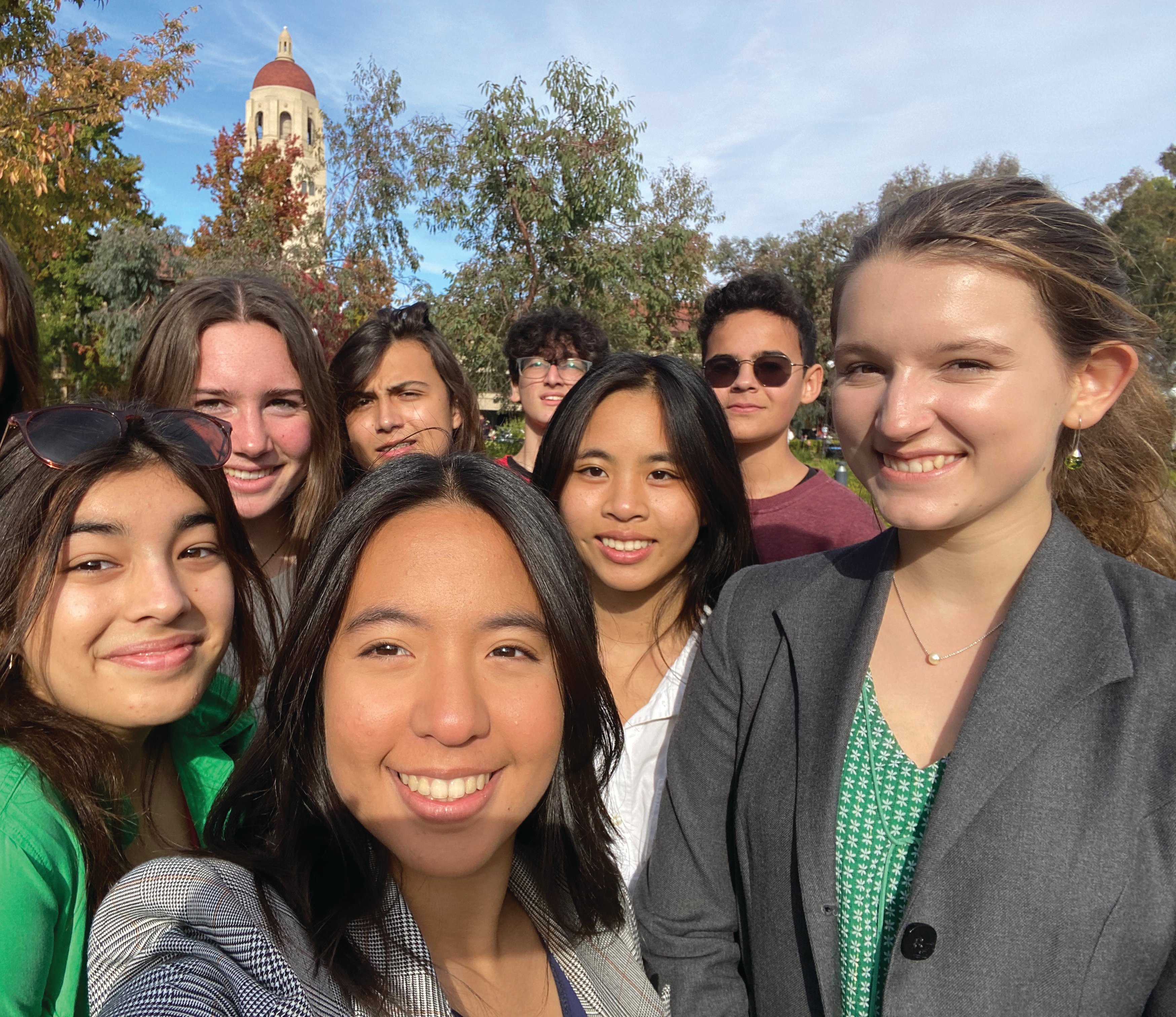 Rox R. taking a selfie with her Model UN teammates on the Stanford Campus with the Hoover Tower in the background.