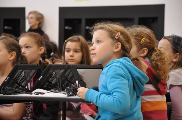 3rd-5th grade students listen to instructions prior to using an "Angry Birds" app on their iPads to learn how to program.