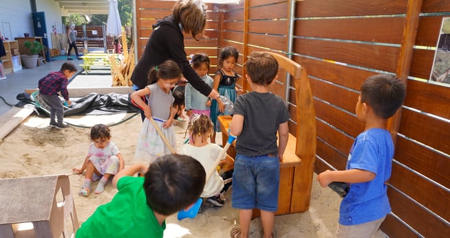 Early Years students play at one of their two new mud kitchen sinks