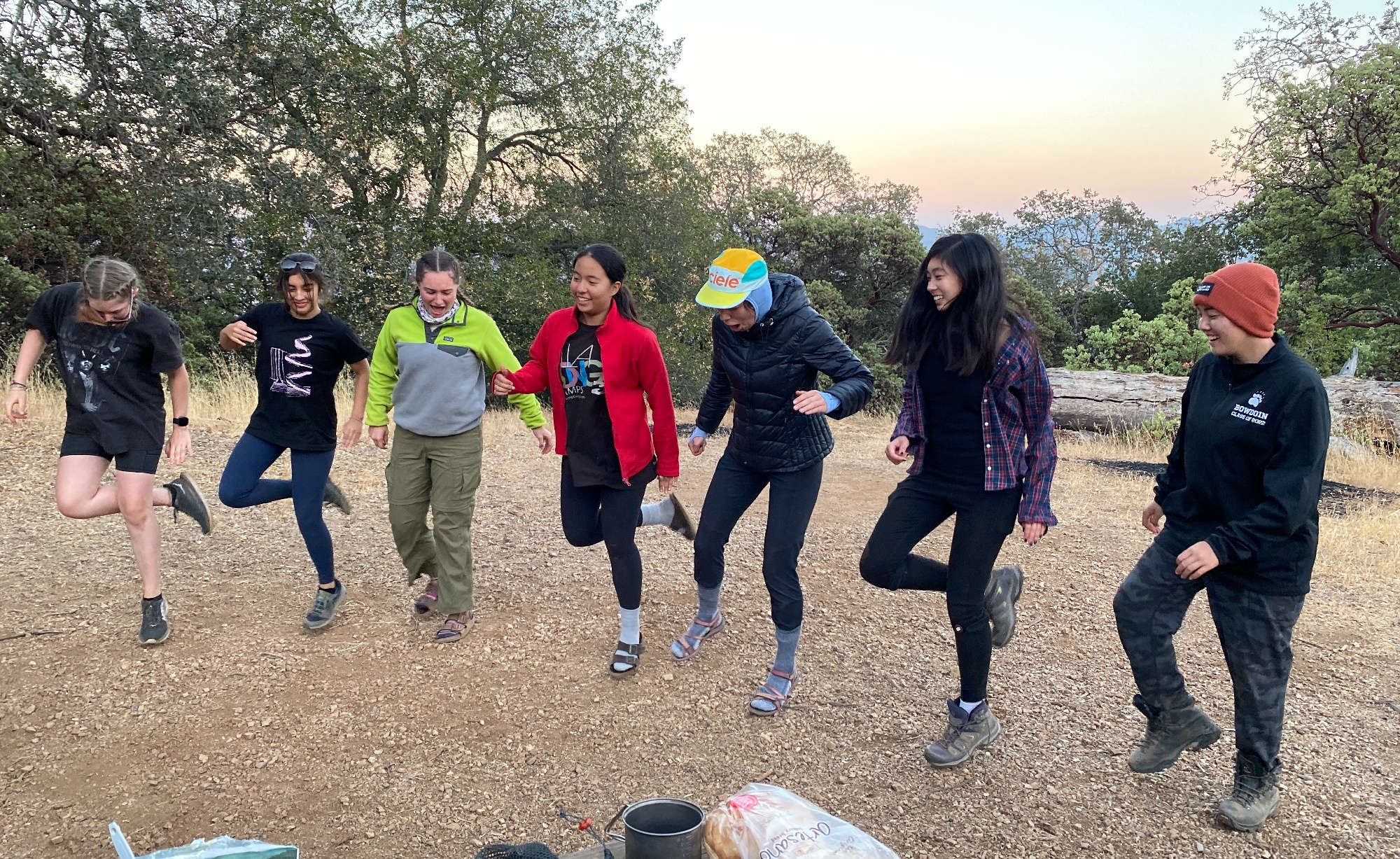 Rox R. in the middle of seven 10th Grade students dancing in camp during the Upper School trip to Henry Coe