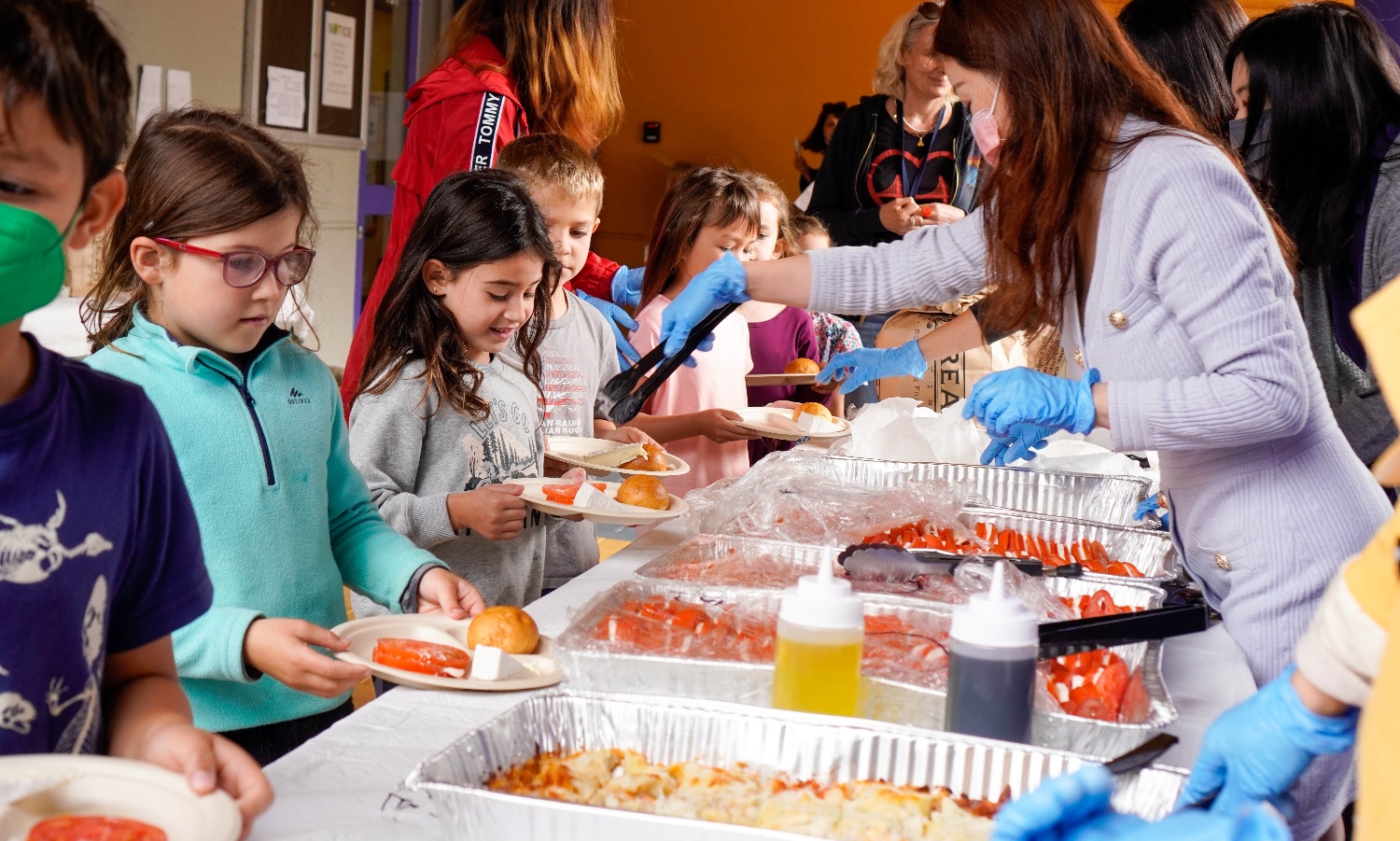 Parent volunteers serving the French-inspired meal for Taste Day at Cohn Campus.