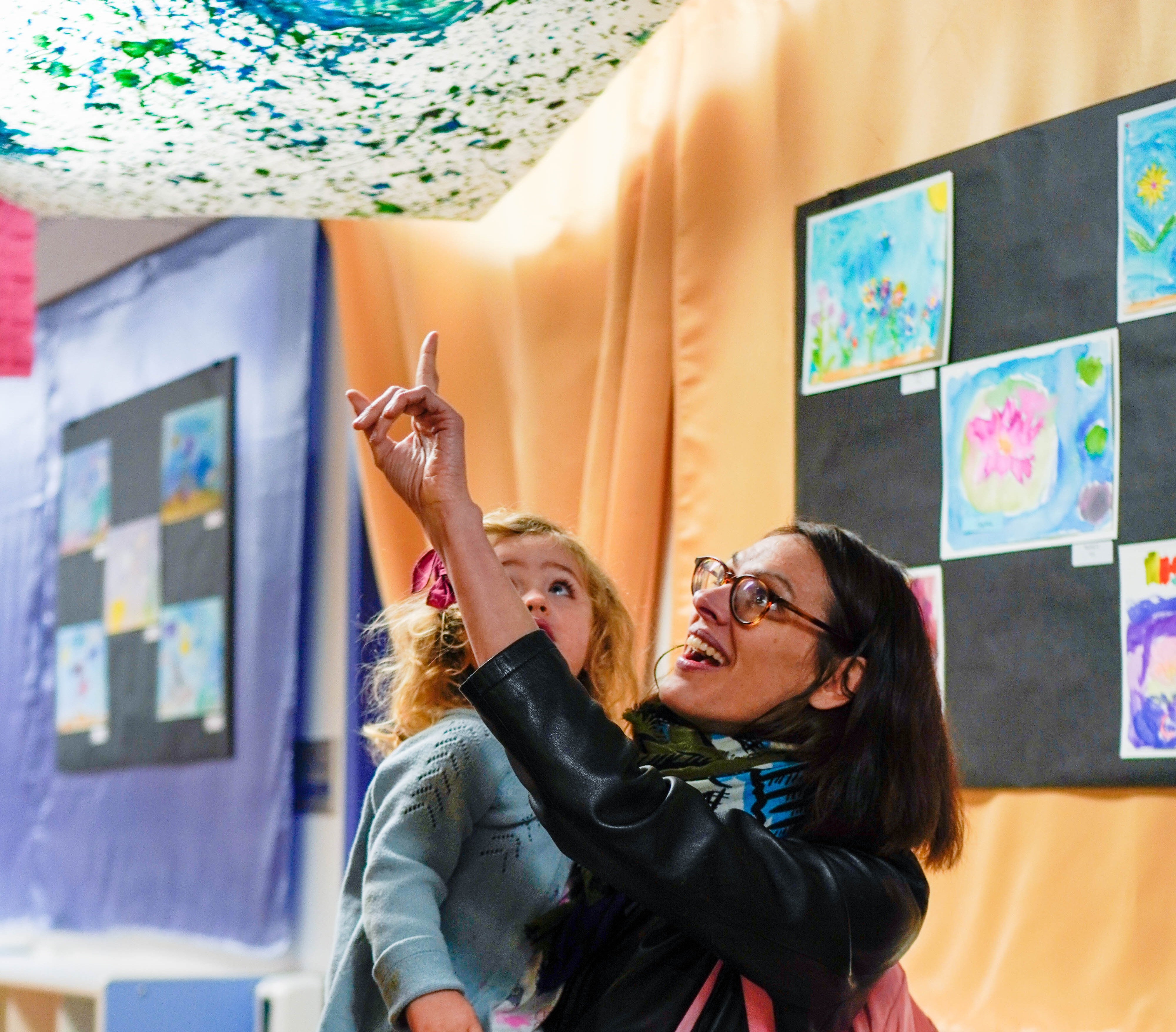 Mother and daughter looking up in awe of the art on the ceiling of Cohn Campus.