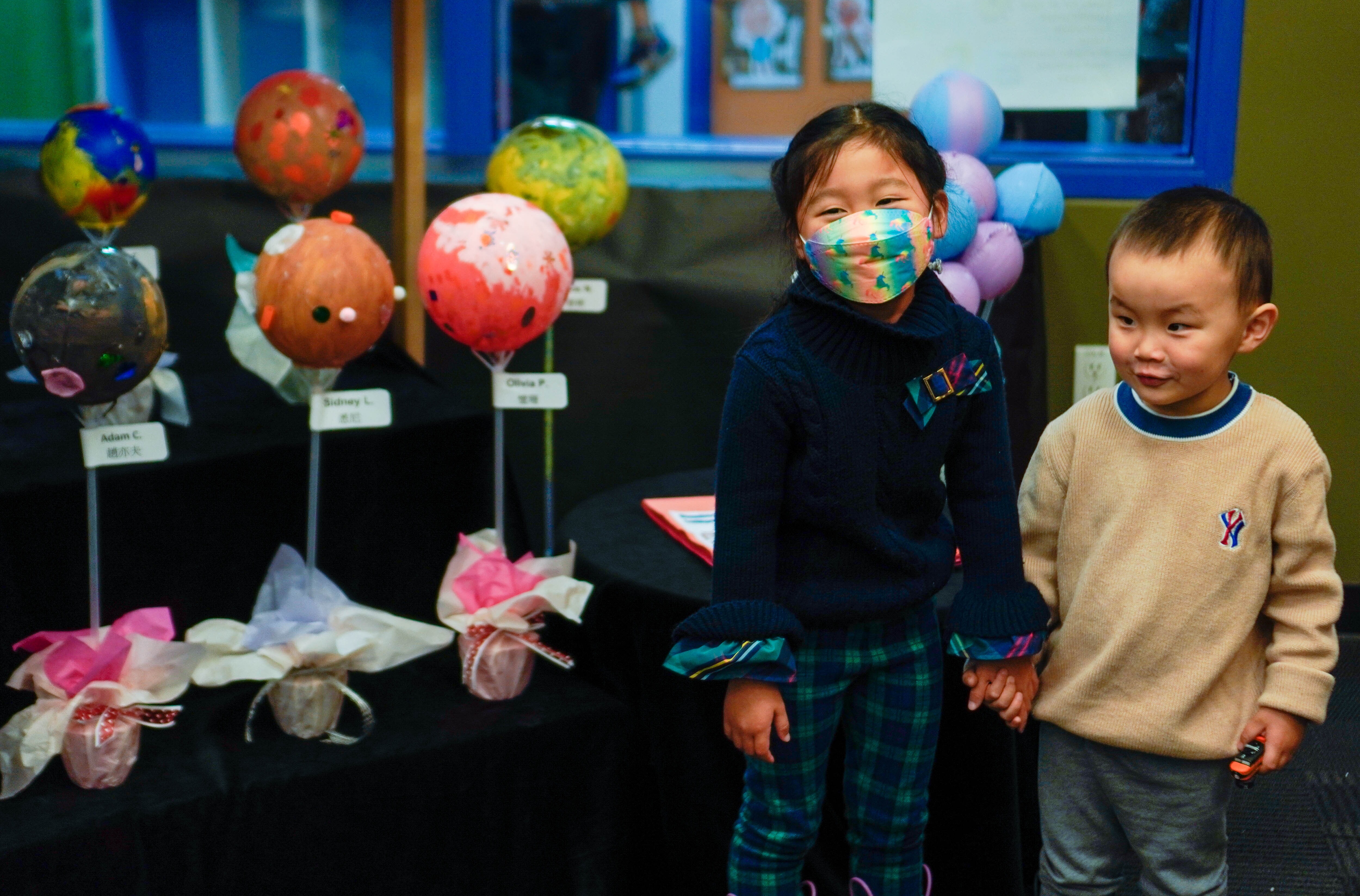 Two young children in front of the paper mache planet display.