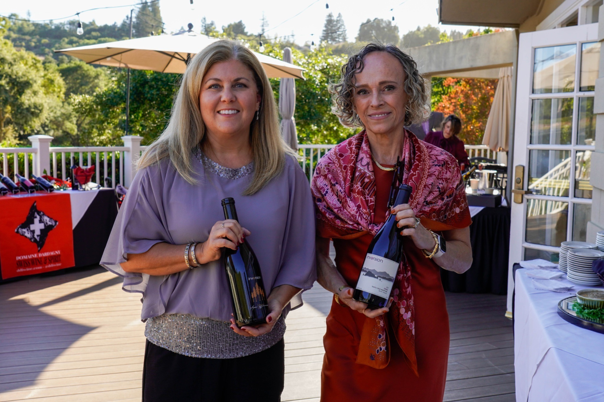 Two vintners holding up their wine bottles from Inversion Wines
