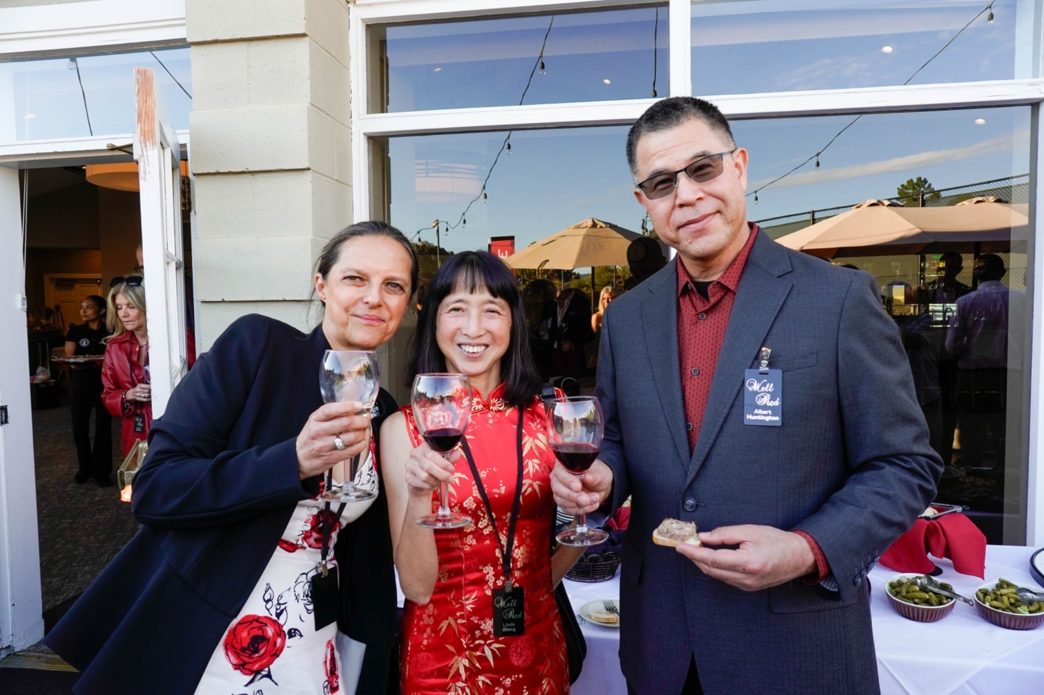 Head of School Barbara Greiner with two board members holding up their wine glasses in celebration