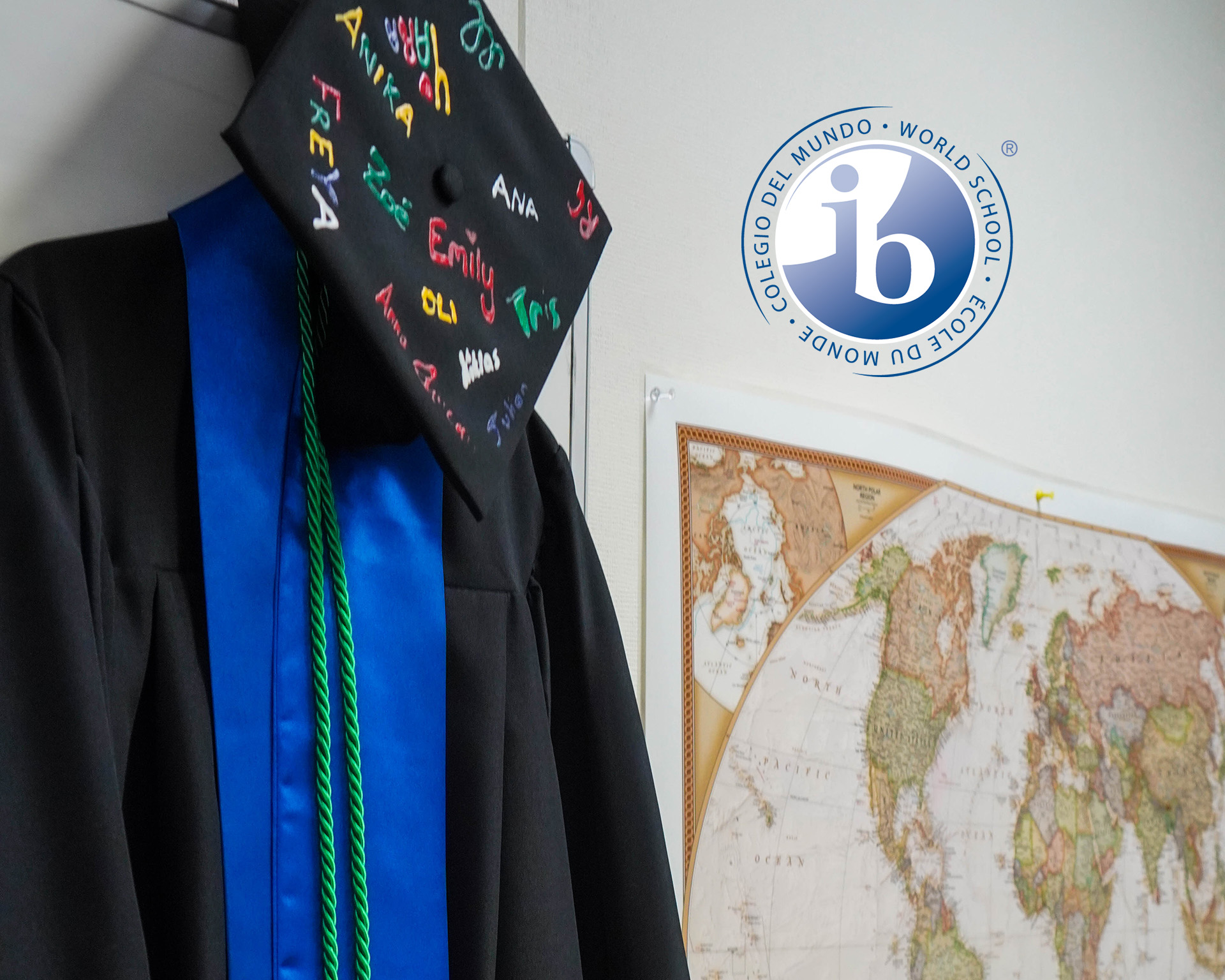 A graduation cap and gown next to a world map.